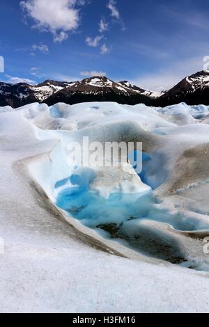 Piccolo lago sul Perito Moreno glaciar formata da estate fusione del ghiaccio con le montagne e un cielo blu su sfondo Foto Stock