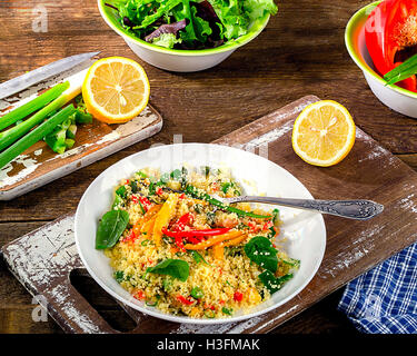 Il couscous con verdure su sfondo di legno. Lay piatto Foto Stock