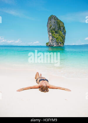 Donna in bikini a prendere il sole sulla spiaggia in Thailandia Foto Stock