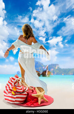 Vista di un womanstanding sulla spiaggia con cappello di paglia e borsa da spiaggia - incentrata sul sacchetto Foto Stock