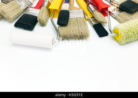 Un assortimento di pennelli e rulli su sfondo bianco Foto Stock