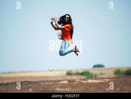 L'immagine di entusiasti teenage ragazza indiana il salto in aria, India Foto Stock