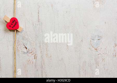 Un bel cuore rosso. Sul vecchio legno bianco sullo sfondo. Foto Stock