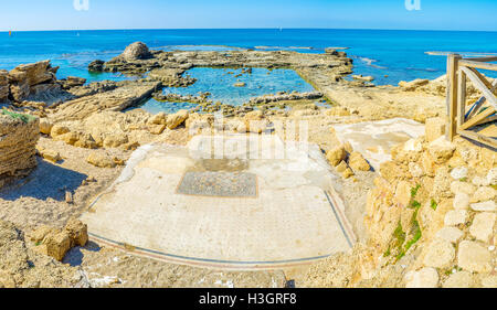 Le rovine dell antico edificio sono parzialmente allagato in mare e la Scenic pavimento a mosaico, conservate sulla riva. Foto Stock