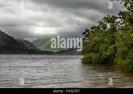 Un raggio di sole penetra il cupo cielo Ullswater, Lake District, Cumbria, Inghilterra Foto Stock