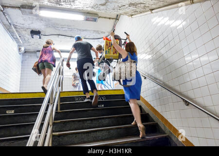 New York City,NY NYC Manhattan,metropolitana,stazione,uscita,scale,MTA,adulti,donna donne,uomo uomo uomo maschio,passeggino,sollevamento,scalini scale s Foto Stock