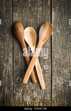 Fatte a mano cucchiai di legno sul vecchio tavolo in legno. Vista dall'alto. Foto Stock