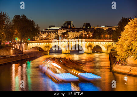 Pont Neuf ponte illuminato e la Senna al crepuscolo con le luci della città e la barca turistica. Ile de la Cite, Parigi, Francia Foto Stock
