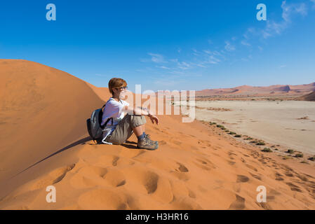 Rilassante soggiorno turistico sulle dune di sabbia e guardando la splendida vista in Sossusvlei, Namib Desert, miglior destinazione di viaggio in N Foto Stock