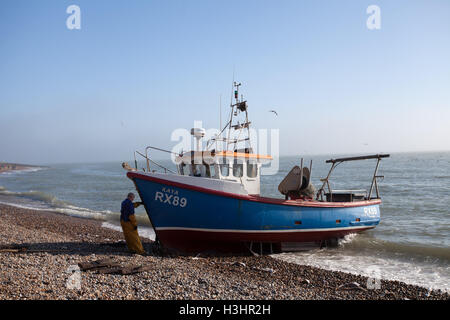 In legno tradizionale barca da pesca è tirare fuori il mare sulla spiaggia di ciottoli allo Stade, Hastings, East Sussex, Regno Unito Foto Stock