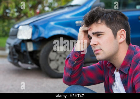 Infelice Autista con Auto danneggiata dopo un incidente Foto Stock