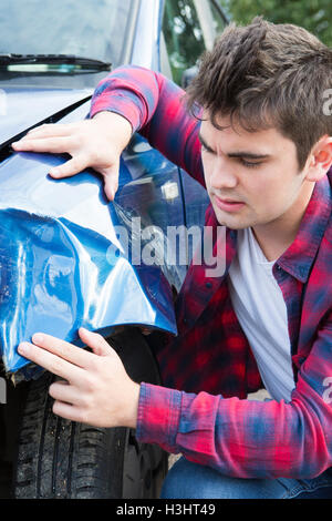 Infelice Autista con Auto danneggiata dopo un incidente Foto Stock