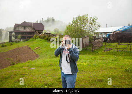 Uomo di scattare le foto sul prato in campagna Foto Stock