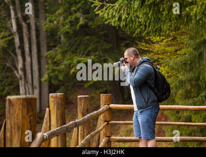 Uomo di scattare le foto sulla veranda della foresta Foto Stock