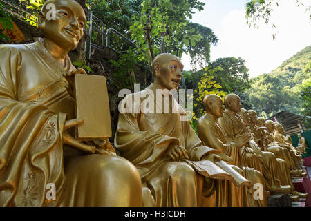 Primo piano della Golden Statue di Buddha lungo il percorso per il Monastero dei Diecimila Buddha (l'uomo grasso Tsz) in Sha Tin (Shatin), Hong Kong. Foto Stock