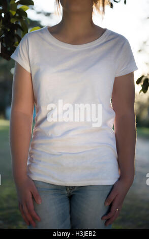 Ragazza giovane waring un fustellato T shirt al tramonto Foto Stock