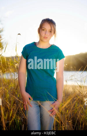 Giovane ragazza al tramonto indossa un fustellato T shirt Foto Stock