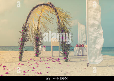 Straordinaria spiaggia matrimoni. In stile vintage. Splendido arco di nozze sulla spiaggia Foto Stock