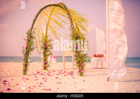 Straordinaria spiaggia matrimoni. In stile vintage. Splendido arco di nozze sulla spiaggia Foto Stock