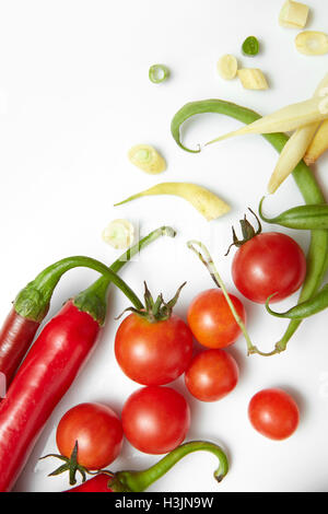 Peperone rosso, giallo e verde fagioli con pomodori ciliegia. Insalata su uno sfondo bianco. Foto Stock