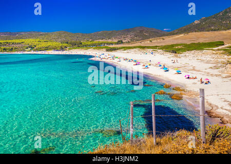 Le persone che si godono il sole sulla sabbia Gran Capo spiaggia con rocce rosse vicino a Ajaccio Corsica, l'Europa. Foto Stock