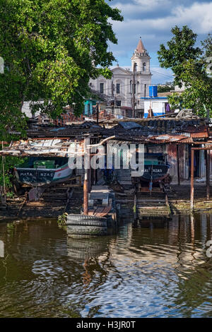 Baracche in barca sul Rio Yumuri River, sostenuta da Iglesia de San Pedro Apostol Chiesa, Matanzas, Cuba Foto Stock