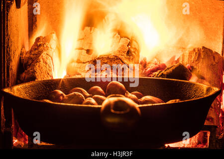 Le castagne la tostatura su un fuoco di legno Foto Stock