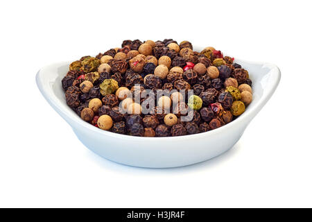 Cumulo di diversi grani di peperoni in un recipiente su bianco Foto Stock