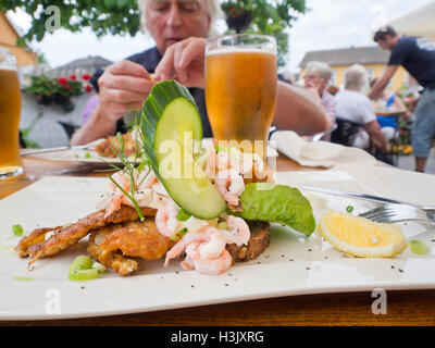 Aprire di fronte sandwich con gamberi e passera di mare, con birra e buona compagnia, un ristorante all'aperto in Drobak Norvegia Foto Stock