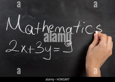 Primo piano della scrittura a mano complicata equazione matematica sulla lavagna nera. Foto Stock