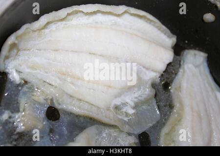 Filetti di platessa in una cottura in padella Foto Stock