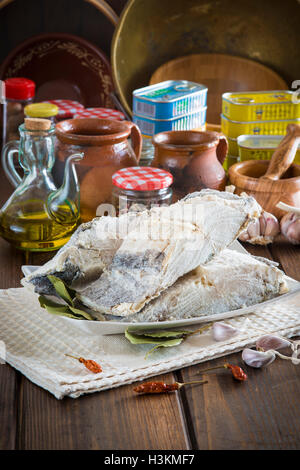 Stoccafisso tagliato con ingredienti e utensili sul tavolo della cucina per cucinare Foto Stock