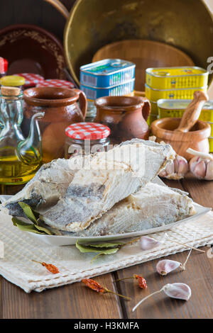 Stoccafisso tagliato con ingredienti e utensili sul tavolo della cucina per cucinare Foto Stock