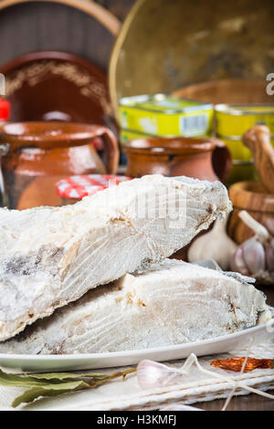 Stoccafisso tagliato con ingredienti e utensili sul tavolo della cucina per cucinare Foto Stock