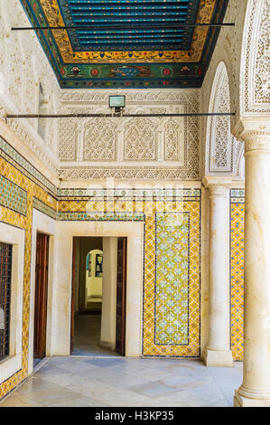 Il interrior della camera a Dar Lasram mansion con scolpito il soffitto in legno e pareti colorate a Tunisi. Foto Stock