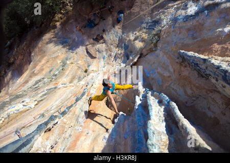 Maschio maturo scalatore estremo appeso sulla forma insolita Rock Foto Stock