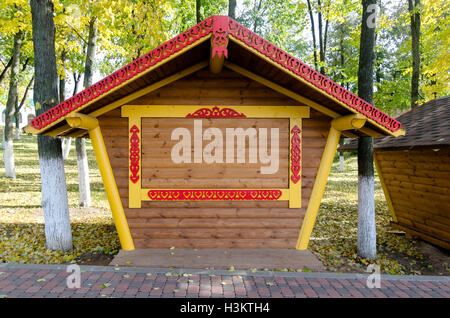 Poster mock up del mercato di strada vuota di stallo in legno sul marciapiede. Il fogliame di autunno intorno a. Golden e il verde delle foglie degli alberi Foto Stock