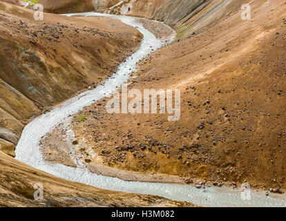 Fiume con il rosso delle colline e il rosso e il nero della lava montagne innevate in Kerlingarfjoll in Islanda. Foto Stock
