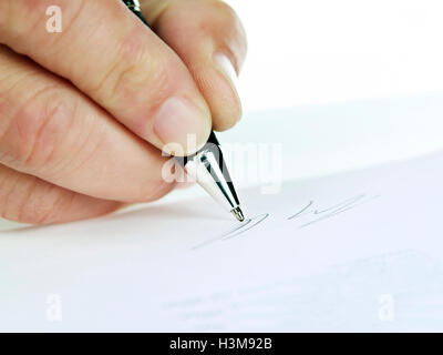 Close-up di una mano mentre firma Foto Stock