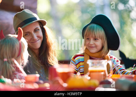 Giovane donna e sua figlia guardando bambina a cena Foto Stock