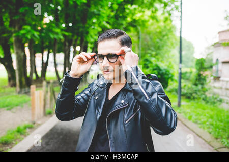 Uomo occhiali di regolazione in posizione di parcheggio Foto Stock