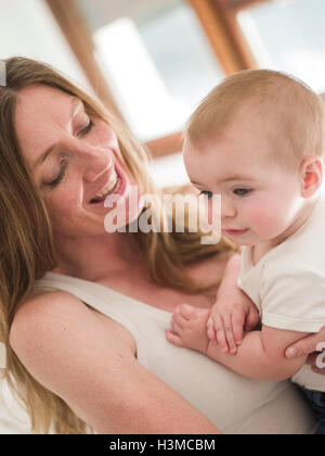 Vista ritagliata della madre sorridente holding Baby girl Foto Stock