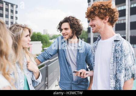 Amici e permanente in chat di fianco alla rotaia Foto Stock