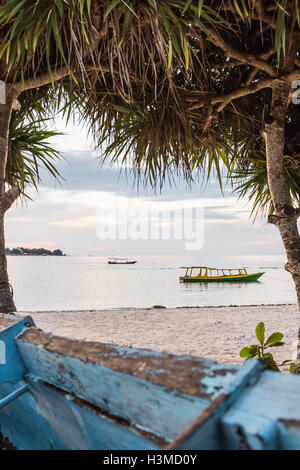 Vista del mare e le barche tra alberi, Gili Meno, Lombok, Indonesia Foto Stock