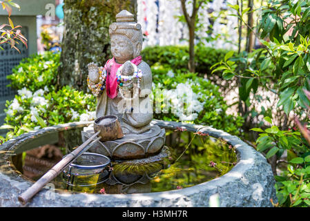 Itsukushima, Giappone - 27 Aprile 2014: una fontana di purificazione in Daisho-nel tempio. Foto Stock