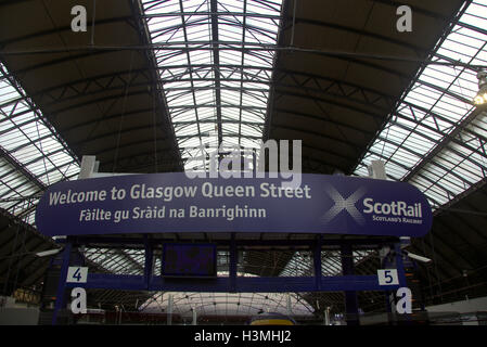 Glasgow tourist viaggiatori che visitano il treno di città in scena con il gaelico stazione di traduzione Foto Stock