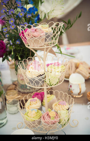 Bello e colorato tortine su un multi-tiered cake stand Foto Stock