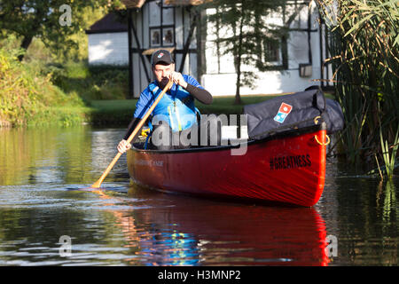 Solo uso editoriale Domino's driver di consegna Robert Isuf pagaie una canoa lungo il fiume sfusi in Maidstone Kent, a consegnare pizza fresca ai clienti in attesa come DominoÃ•s annuncia che sta provando una via navigabile servizio consegna nel lato del canale villaggio. Foto Stock