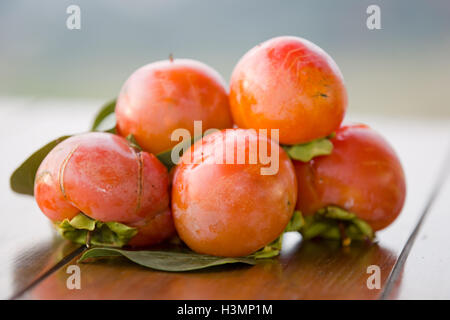 Persimmons maturi su un tavolo, per esterno Foto Stock