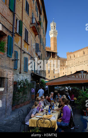 Grande gruppo di amici per mangiare al fresco presso la Trattoria Papei, 6 Piazza del Mercato, Siena, Toscana, Italia Foto Stock